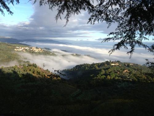 a view of a valley with fog in the hills at Il ghiro in Montevarchi