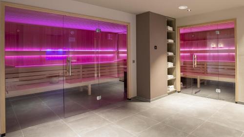 a bathroom with purple lights on the walls at Country Hotel Timmendorfer Strand in Timmendorfer Strand