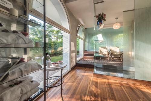 um quarto com paredes de vidro e uma mesa e cadeiras em Acqua Resorts em Sirmione