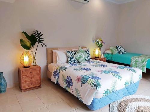 a bedroom with a bed and two lamps on tables at Mudha Sindu Sanur 2 Bedrooms in Sanur