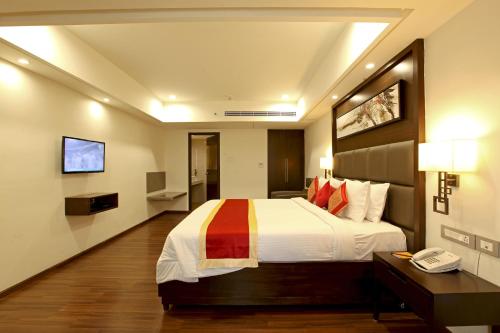 a hotel room with a bed and a telephone at Goutham Grand Hotel in Tenāli