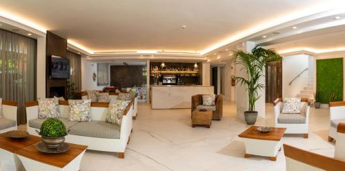 a lobby with white chairs and tables and a bar at Atlas Hotel in Riccione