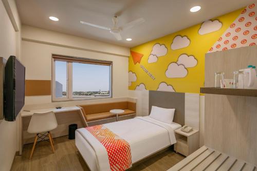 a bedroom with a bed and a desk and a window at Ginger Patna in Patna