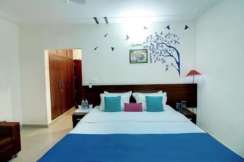 a bedroom with a blue bed with birds on the wall at STAAYZ Premium Gurgaon in Gurgaon