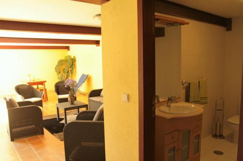 a bathroom with a sink and a living room at Casa de José in Cabeceiras de Basto