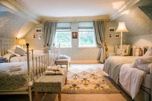 a bedroom with two beds and a window at Scatwell House in Garve