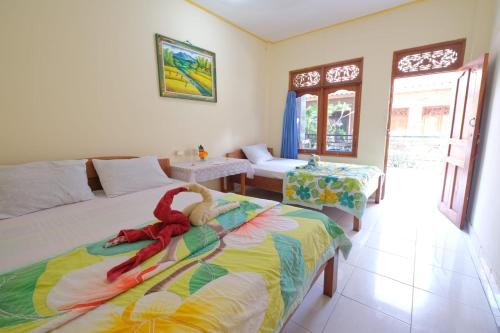 ein Schlafzimmer mit zwei Betten mit einem ausgestopften Tier darauf in der Unterkunft Kabera House 2 in Ubud