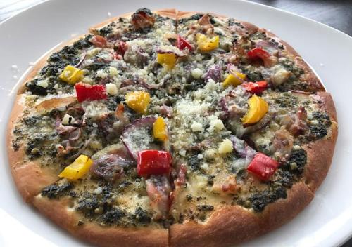 a pizza sitting on top of a white plate at Pension Kamifuji in Osaki