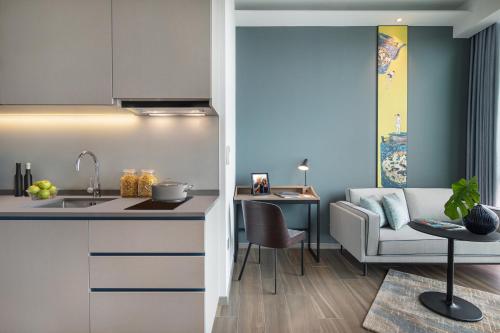 a kitchen and a living room with a couch at Citadines Balestier in Singapore