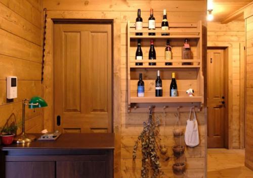 a room with a bunch of bottles of wine on shelves at Pension Kamifuji in Osaki