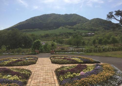 a brick walkway with flowers in a garden at Pension Kamifuji in Osaki