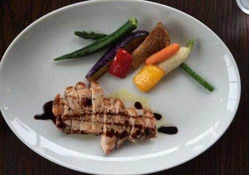 a white plate with meat and vegetables on a table at Pension Kamifuji in Osaki