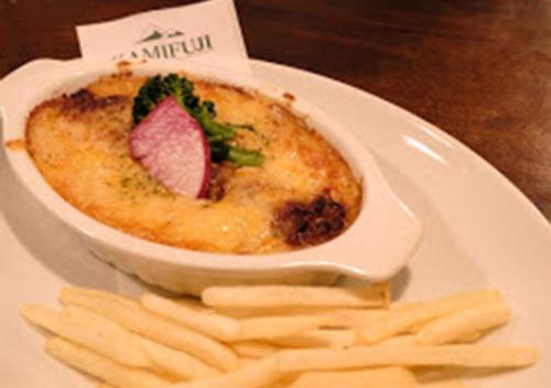 a white plate with a bowl of food and fries at Pension Kamifuji in Osaki