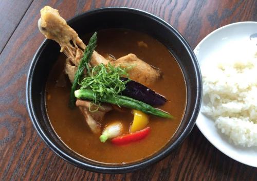 a bowl of soup with vegetables and rice on a table at Pension Kamifuji in Osaki