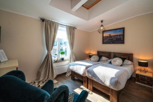 una camera da letto con un letto, un divano e una finestra di Apartments 17 Szewska a Cracovia