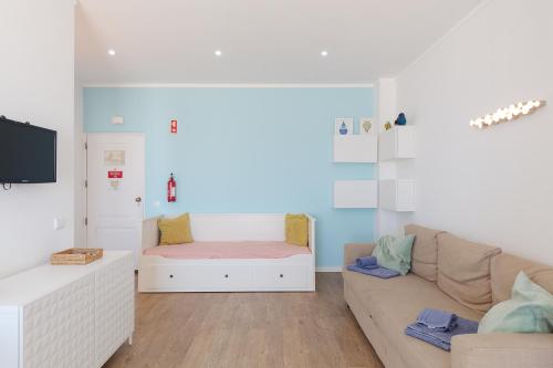 a living room with a couch and a bed at Pé na Praia in Albufeira