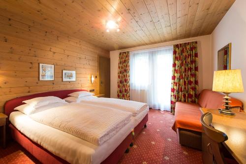 a bedroom with a large bed and a window at Appartementhaus Holiday in Lech am Arlberg