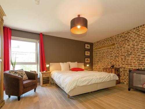 1 dormitorio con 1 cama y 1 silla en Magnificent character cottage with hot tub, en Marche-en-Famenne