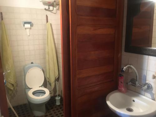 a bathroom with a toilet and a sink at Hotel O Sole Mio in Assinie