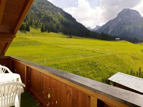 a porch with a view of a green field and mountains at Appartementhaus Holiday in Lech am Arlberg