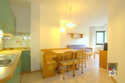 eine Küche und ein Esszimmer mit einem Tisch und Stühlen in der Unterkunft Residenza Artini in Comano Terme