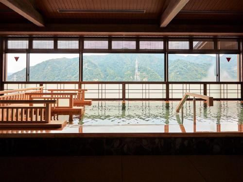 a room with a bathtub with a view of a mountain at Yukinohana in Yuzawa