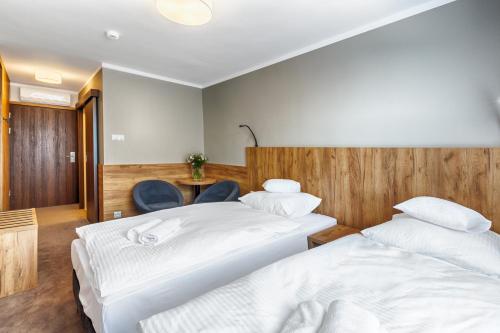 a hotel room with two beds and a table at Hotel Tarnovia in Tarnów