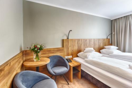a hotel room with two beds and a table and chairs at Hotel Tarnovia in Tarnów