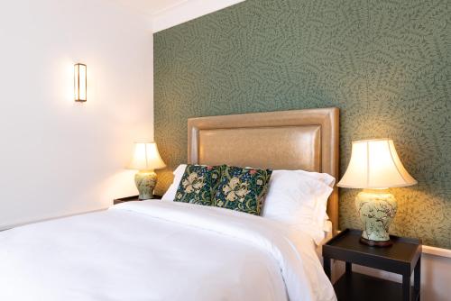 a bedroom with a bed and two lamps on tables at Gunmakers in London
