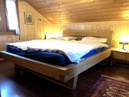 a bedroom with a large bed in a wooden room at Charmant Petit Chalet 3 étoiles en Gruyère in Crésuz