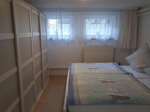 ein kleines Schlafzimmer mit einem Bett und einem Fenster in der Unterkunft Ferienwohnungen Seebad Ahlbeck in Ahlbeck