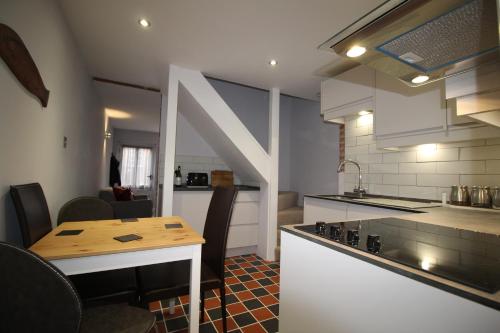 a kitchen with a table and a stove top oven at 1 Steam Packet Cottage in Canterbury