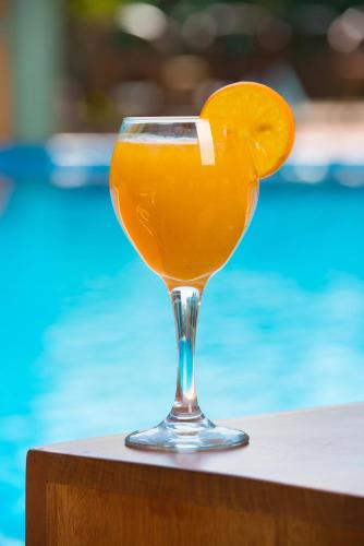 a glass of orange juice with an orange slice at Dolphin Suites in Kampala