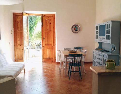 cocina y sala de estar con mesa y sillas en Villa San Lorenzo, en Reitani