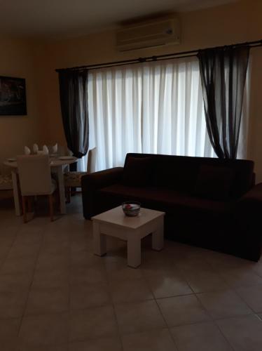 a living room with a black couch and a table at Sunrise Beach Club (Hera B6@) in Kalecik
