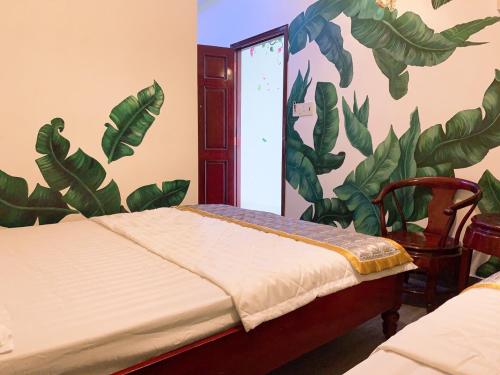 a bedroom with a bed with a mural of leaves at Nam Phương Hotel Sa Đéc in Sa Ðéc