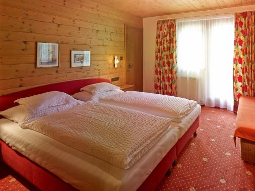a bedroom with a large bed in a wooden room at Chalet Rüfikopf in Lech am Arlberg