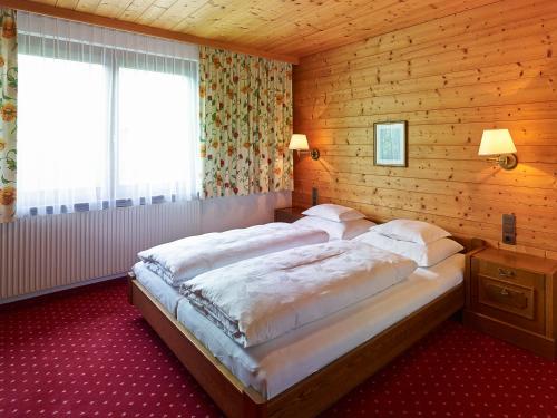 a bedroom with two beds in a wooden room at Chalet Rüfikopf in Lech am Arlberg