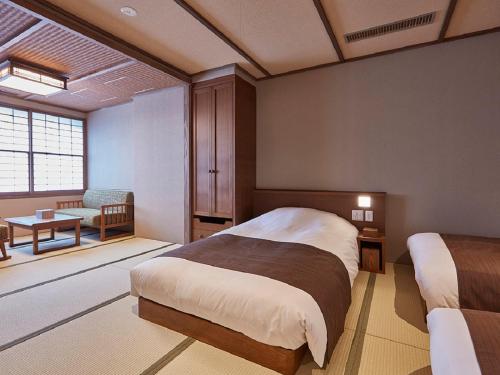 a bedroom with two beds and a table and a chair at Yukinohana in Yuzawa
