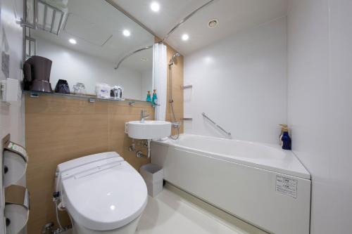 a bathroom with a white toilet and a sink at Shizutetsu Hotel Prezio Kyoto Shijo in Kyoto