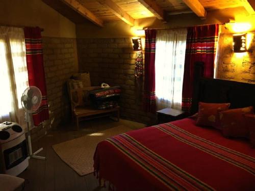 a bedroom with a red bed in a room with windows at Casa Nativo - The Heart of the Vineyard in Valle de Guadalupe