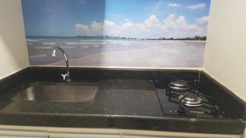 un lavandino da cucina con vista sulla spiaggia di Victory Flat Intermares n 64 ap 406 a Cabedelo