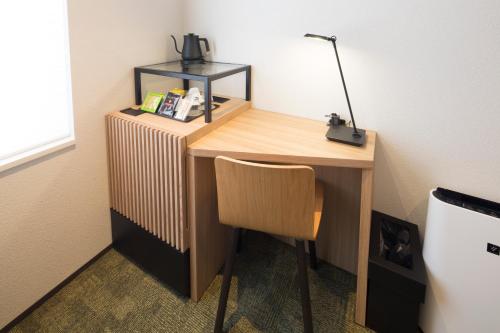 a desk with a chair and a lamp on it at Shizutetsu Hotel Prezio Kyoto Shijo in Kyoto
