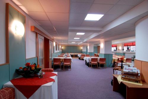 a dining room with tables and chairs and tablesktop at Hotel KAMU GARNI in Vsetín