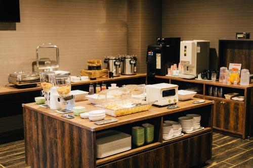 a kitchen with a counter with dishes and a microwave at The Celecton Kurashiki Mizushima in Kurashiki