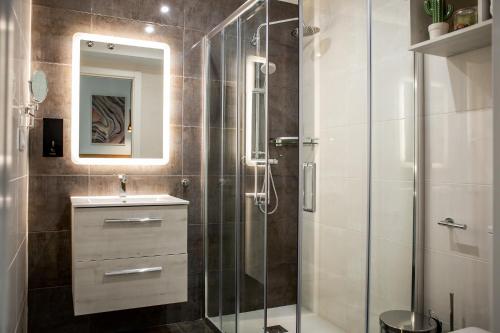 a bathroom with a glass shower and a sink at Apartamentos Turísticos Moret 11 - 1C in Cáceres