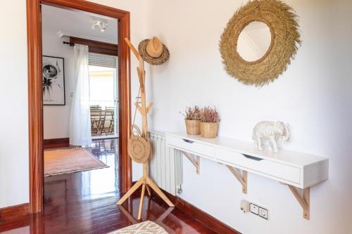 ein Wohnzimmer mit einem Spiegel und einem weißen Regal in der Unterkunft Canido, Vigo, Rias Baixas in Oya