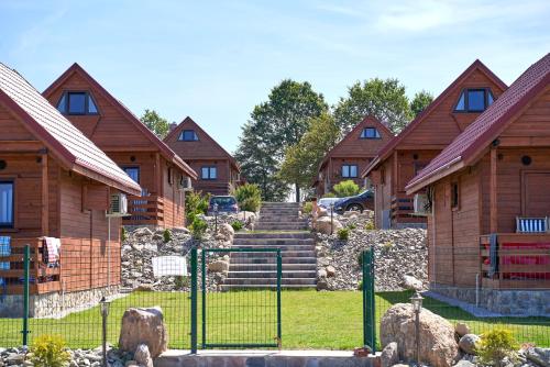 a group of wooden houses with a gate in front at Rancho Zapotoczny in Łagów