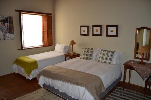 a bedroom with two beds and a window at Over The Mountain Guest Farm in George
