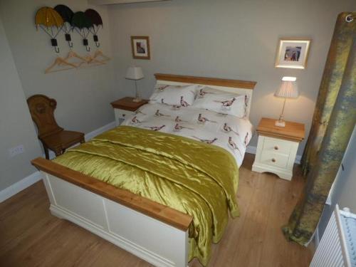 a bedroom with a bed with a green comforter at No6 @ Globe Lane,Alston in Alston